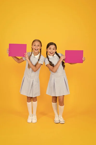 Amigos felizes em uniforme retro. moda de criança vintage. de volta à escola. meninas pequenas segurar papel em branco. livro de enciclopédia para crianças. meninas pequenas amam literatura. Velha escola. anúncio. espaço de cópia . — Fotografia de Stock