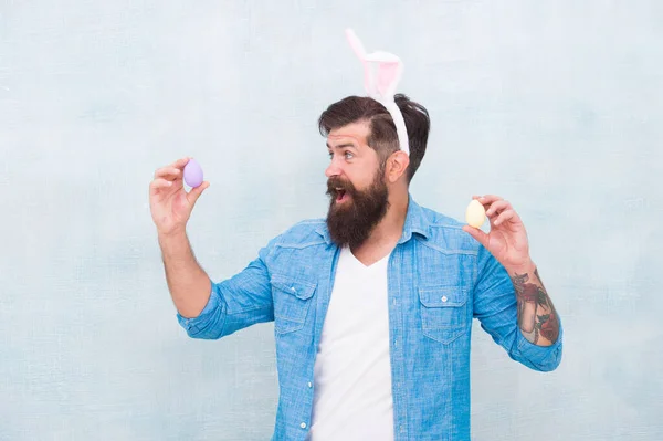 Людина в вухах кролика тримає яйце. Час весни. Пасхальні яйця. З Великоднем. Бути плідним. Святкування весняних канікул. Пасхальна їжа. Кольорові яйця ручної роботи. Яйця гіпстерів на Великдень — стокове фото