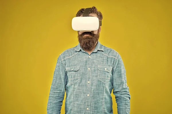 Future is closer than you think. Bearded man explore VR yellow background. VR technology and future. VR communication. Exciting impressions. Hipster wear VR glasses. Gaming and entertainment