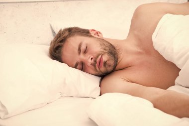 Uykudan uyanma döngüsünü sirkadyan ritmi düzenler. Yatakta tıraş edilmemiş yakışıklı bir adam. Her gece yeteri kadar uyuyorum. Bahşişler daha iyi uyuyor. Sakallı adam yastıkta dinleniyor. Yumuşak yastık. Sağlık hizmeti kavramı