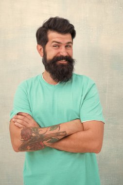 Rahat ol, kendin ol. Sıradan kıyafetli mutlu hippi kollarını kavuşturuyor. Sakallı adam, sıradan bir şekilde gülümsüyor. Rahat ve rahat.