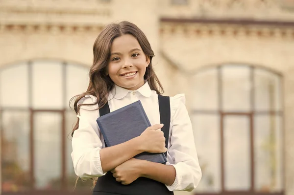 Wieder im Lernmodus. glückliches Kind halten Bibliotheksbuch. kleines Mädchen zurück in den Unterricht. muss zurück zu den Grundlagen der Schule. bereit, zurück zum Studium zu gehen. Bildung und Wissen — Stockfoto