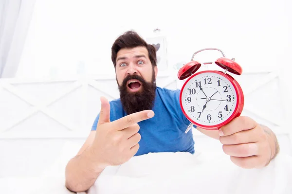 Unhappy man pointing at the alarm clock. hate noise of alarm clock. Man awake with retro alarm clock ringing. sick and tired of insomnia. wakes up in morning. time and aging concept — Stock Photo, Image