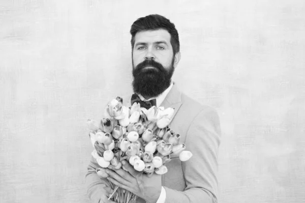 Virágot neki. Férfi szakállas öltöny csokornyakkendő tartja tulipán csokor. Egy úriember romantikus meglepetést készít neki. Virágok szállítása. Úriember romantikus randi. Szülinapi üdvözlet. Legjobb virágok barátnő — Stock Fotó