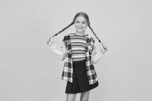 Chica preadolescente ropa colorida. Centro comercial para niños. Adorable cara hermosa chica. Peluquería. Niña. Niño pequeño con lindas trenzas peinado sobre fondo amarillo. Concepto de cuidado infantil — Foto de Stock