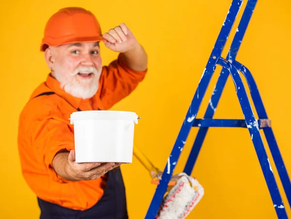 Haus Malerei und Renovierung Geschäft. Reparaturwerkzeug herstellen. Maler auf der Baustelle. Senior benutzte Roller auf Leiter. Arbeit in der Wohnung. Handwerker mit Farbwalze. Selektiver Fokus — Stockfoto