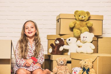 Hayat burada daha güzel. Taşınma konsepti. Yeni daire. Karton kutular yeni eve taşınıyor. Yeni bir yaşam alanı satın almak. Oyuncağı olan mutlu küçük bir kız. Mutlu çocuk karton kutu