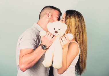 Hamilelik konsepti. Birbirine aşık erkek ve kadın. Aile sevgisi. Aşık bir adam ve güzel bir kız. Kız ve erkek sarılıyor. Gelecekteki ebeveynler. Mutlu bir aile. Sevgililer Günü tatili. Yumuşak oyuncak ayı hediyesi