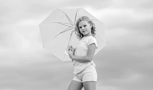 楽しみ方だ屋外で気をつけて傘の曇った空の背景を持つ女の子。自由と新鮮さ天気予報。どんな天気でもいいです。天気が変わる。新鮮な空気だ幸せな子供の日 — ストック写真