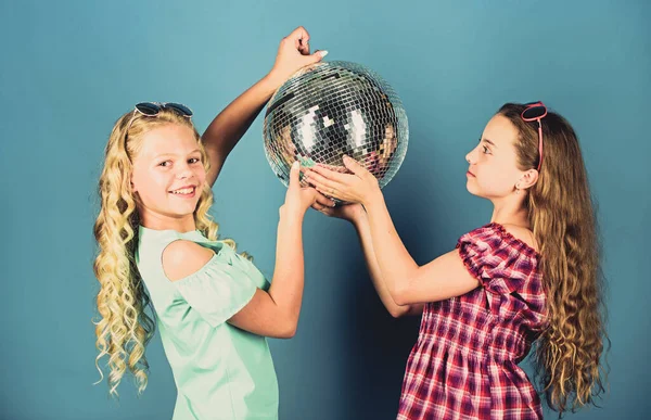 Retro music. Mirrors reflecting lights disco atmosphere. Holiday celebration. Entertainment concept. Sisters friends with disco ball. Lets start party. Cheerful kids hold disco ball. Disco dances