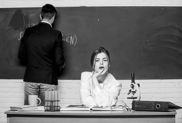 Estudiando para exámenes. La mujer sensual enseña al hombre barbudo a examinarlo. Estudiante universitario aprobando examen final de grado. Prueba de conocimiento. Examen en química o biología — Foto de Stock