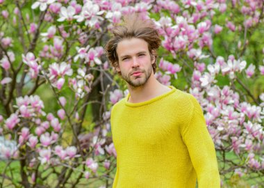 Bahar güzeli. Botanik bahçesi. Erkek çiçek arka planı. Tazelik ve uyanış. Bahar ilham. Baharın neşesi. Modern hipster çiçekleri sever. İlkbahar konsepti. Adam çiçek parkında rahatlıyor.