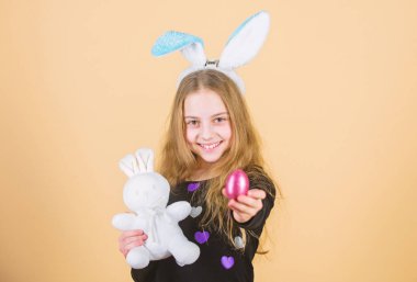 Paskalya yortusu yumurta Festivali kapsamında avlıyor. Paskalya tavşanı kökeni. Paskalya semboller ve gelenekleri. Yumuşak oyuncak oynak çocukla. Bahar tatil karşılamak. Kız küçük çocuk Paskalya bunny Aksesuar tutun boyalı yumurta