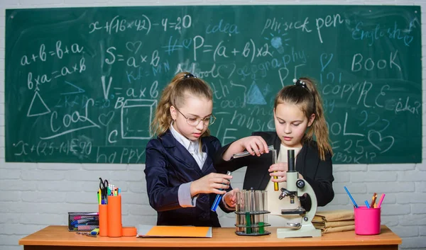 Detta är vad vi testar i dag. Biologilektion. Vetenskapliga experiment i bilogilaboratorium. Små flickor i skolans labb. Biologiutbildning. Liten forskare arbetar med mikroskop. Kemisk forskning — Stockfoto