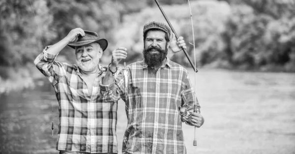 釣り竿を持つ漁師。ひげを生やした男が魚を捕まえる友人釣りを持つ成熟した男。夏休み。幸せな陽気な人々。家族の時間だ活動と趣味。釣り淡水湖池川 — ストック写真