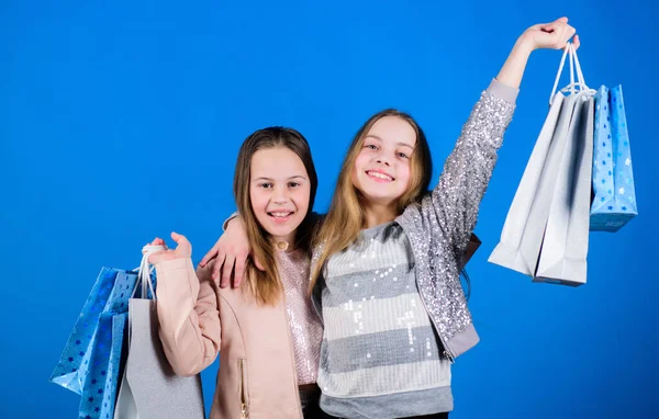 Gelukkige kinderen. Kleine meisjes zusjes genieten van online winkelen. Kleine meisjes met boodschappentassen. Verkoop en kortingen. Zusterschap en familie. besparingen op aankopen. Kindermode. Thuis winkelen — Stockfoto