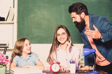 Aşırı korumacı bir aile. Aşırı korumacı ebeveynlik tarzı. Ödev yapan küçük bir kız. Baba anne çocuğa öğretiyor. Zeki bir aile. Aşırı korumacı ebeveynlik tarzının en büyük dezavantajı yetersiz hazırlanmış çocuklar