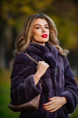 Lüks ve başarı konsepti. Kürk giymenin faydaları. Zarif bir kadın kürk giyiyor. Güzellik ve moda. Sonbahar ve kış tarzı. Eşsiz bir sıcaklık. Sahte kürk gerçek kürke karşı. Görsel estetik