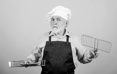 Lezzetli ve lezzetli. Barbekü için mutfak aletleri. Sağlıklı beslenme şekli. Barbekü ve füme yemek. Izgara yemek. Piknik ve barbekü konsepti. Mangal konsepti. Olgun sakallı şef ızgara ızgara ızgarası tutuyor.