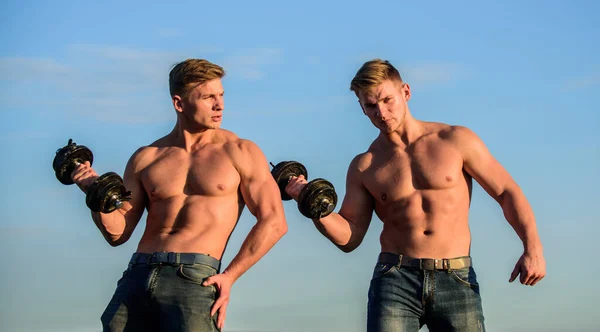 Sterke en fitte mannen bodybuilders. Een tweeling gespierde mannen. atletische man sexy lichaam. Sportieve gespierde jongens met lange halters en halters. Een tweeling die samen traint. Spierkracht en spierkracht ontwikkelen — Stockfoto