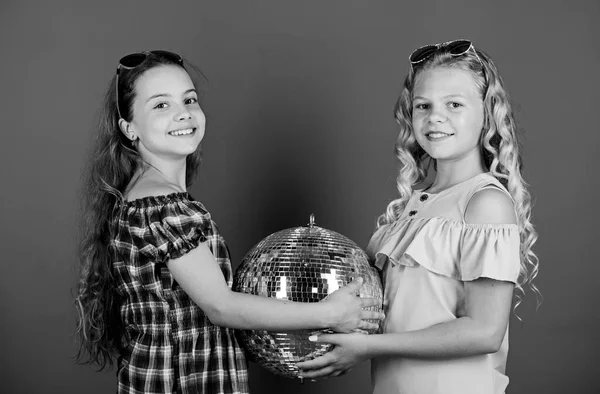 Сестры дружат с диско-шаром. Начнем вечеринку. Веселые дети держат диско-мяч. Диско-танцы. Ретро музыка. Зеркала, отражающие атмосферу диско света. Праздник. Концепция развлечений — стоковое фото