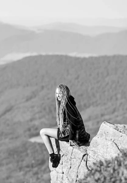 På gränsen till världen. Kvinna sitter på kanten av klippan i höga berg landskap bakgrund. Vandring i lugn och ro. Njut av utsikten. Turistvandrare flicka avkopplande kant klippa. Farlig avslappning. Extremt koncept — Stockfoto