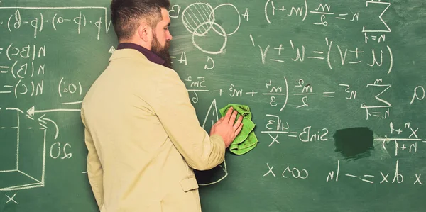Prepare for lesson. Teacher bearded man cleaning chalkboard background. Teacher wiping chalkboard. School principal. Demanding teacher. Lecturer in classroom. Explaining theory. Teacher hold rag
