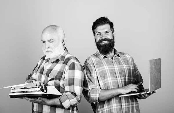 Digital technologies. bearded men. Vintage typewriter. technology battle. Modern life. father and son. family generation. retro typewriter vs laptop. New technology. youth vs old. business approach — Stock Photo, Image