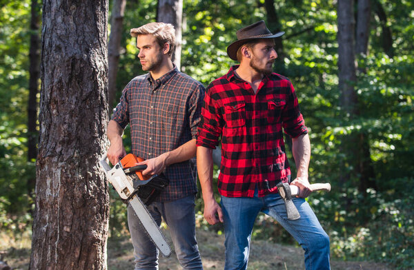 hiking in deep wood. forest care at vacation. summer or spring activity. man farmers relax in forest. rangers use lumberjack equipment. Lumberjack with chainsaw and ax. Harvest firewood