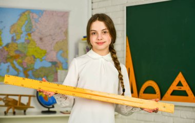 Eğitim ve üniversite. Liseli kız cetvel tutuyor. Ölçüm Cihazı. farklı okul unsurları. Sonbahar okulunda kırtasiye malzemesi. Okula dönelim. Üniversitede eğitim. geometriye gömülmüş