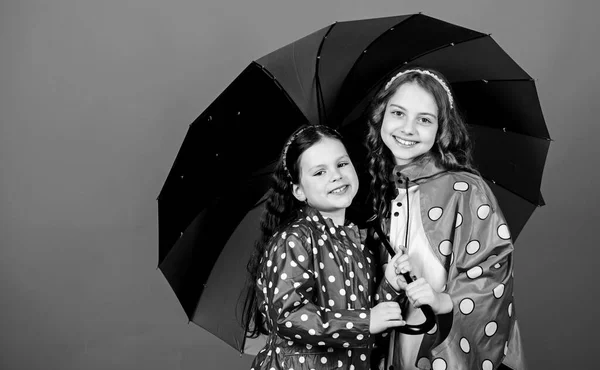 명랑 한 어린이, 자매. 비를 막아주는 장치. 레인보우. 가을 패션. 화려 한 우산을 두른 행복 한 어린 소녀들. 가족의 유대. 비옷입은 여자 애들. 야영의 중요 한 부분 — 스톡 사진