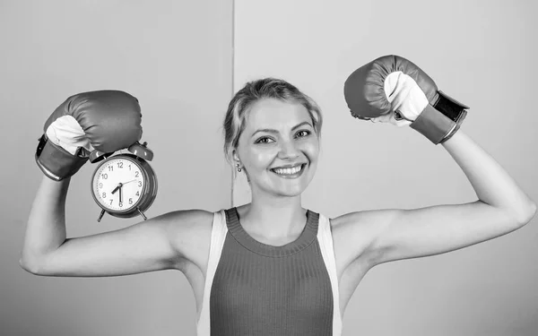 Puntualidad y eficiencia personal. Habilidades de gestión del tiempo. Batalla por la autodisciplina. Mujer sosteniendo guantes de boxeo. Boxeador luchando con despertador. Hora del entrenamiento de boxeo. Tiempo de control — Foto de Stock