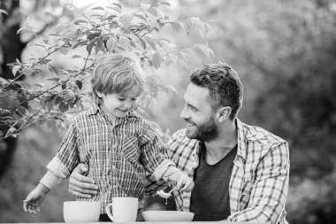 Mutlu aile birlikte. Çocuk gelişimi. çocukluk mutluluğu. Sağlıklı yemek ve diyet. Aile günü. Babalar günün kutlu olsun. Babası dışarıda olan küçük bir çocuk. Oğul ve baba sütlü yulaf lapası yiyor. Güzel yemek.