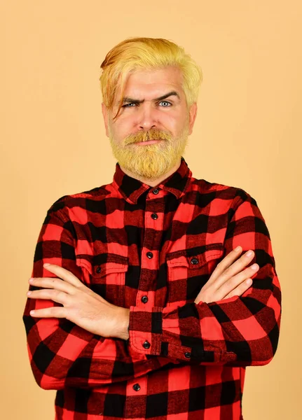 Male beauty standards. bearded man checkered shirt. mature hipster dyed beard. hairdresser and barbershop. brutal male blonde hair portrait. unhappy man casual fashion. barber master with moustache