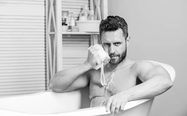 Hygiène et santé. Concept de sexualité et de relaxation. soins personnels. Homme sexy dans la salle de bain. désir et tentation. Macho s'assoit nu dans la baignoire à laver avec une éponge. homme lavage corps musculaire avec éponge — Photo