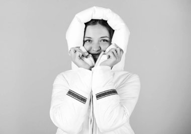 Beyaz ceket giyen bir kız. Ceketin ekstra yalıtımı var ve vücudunu sert kış havasından korumak için biraz daha uzun. Süslü, şık kışlık kıyafetler. Her ceket her iklim için ideal değildir.