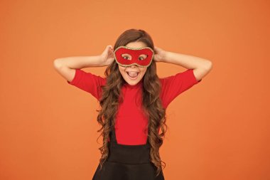 Karnaval eğlence dükkanı. Mutlu çocuk eğlence için Venedik maskesi takıyor. Küçük kız gizemli turuncu geçmişiyle eğleniyor. Havalı maskeli balo eğlencesi. Tatil kutlaması. Parti ve eğlence