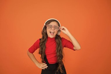 DJ diskosu için kablosuz kulaklık kullanıyor. Küçük mutlu kız kulaklıkla müzik dinliyor. Parti gözlüklü komik çocuk. Zaman geçiyor. Modern çocuk müzikten hoşlanıyor. Şık ve kendinden emin hissediyorum. Okul radyosu DJ 'i
