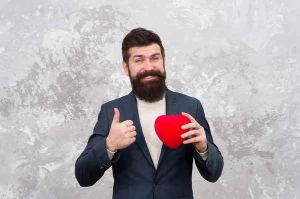 Excelentes ideias de celebração para baixo orçamento. Apaixone-se. Conceito de amor e romance. Homem barbudo segurar brinquedo de pelúcia coração vermelho. Feliz Dia dos Namorados. Celebra o amor. Loja de presentes. Cavalheiro prepare-se para a data — Fotografia de Stock