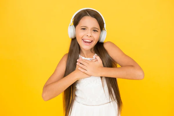 Happy child enjoy listen to music in headphones. small girl enjoying DJ music. happy childhood concept. back to school. online education and communication. music in wireless earphones. Musical taste — Stock Photo, Image