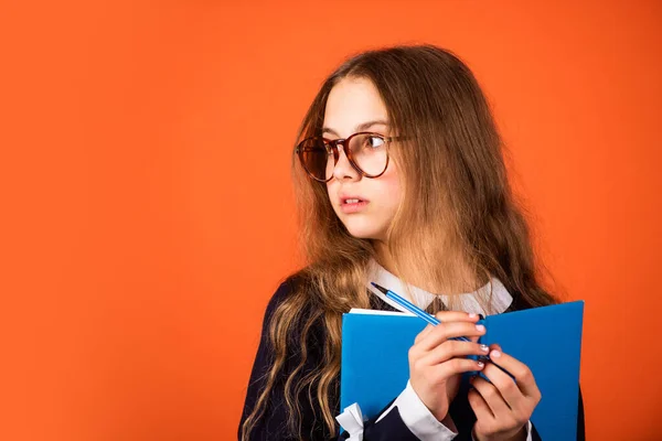 Sei schlau. Smart Mädchen braunen Hintergrund. Kleines Mädchen zurück in die Schule. Kleines Mädchen liest Buch in Brille. Grundschulmädchen mit langen Haaren. Schule und Bildung, Kopierraum — Stockfoto