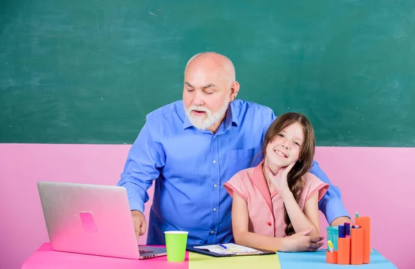 Levens beter maken. De lerares helpt schoolmeisje. klein meisje met man tutor studie op laptop. online onderwijs. Terug naar school. moderne leertechnologie. winkelen op school. Een essay schrijven — Stockfoto