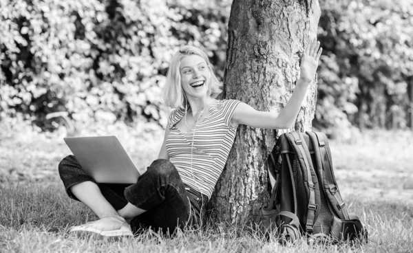 Работа в летнем парке. Девушка работает с ноутбуком в парке. Причины, по которым ты должен вынести свою работу наружу. Студентка сидит на траве во время учебы. Природа главное благополучие и способность быть продуктивным — стоковое фото