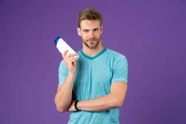 Cildime değer veriyorum. Neşeli yakışıklı sporcu elinde şişe şampuan duş jeli tutuyor. Erkekler için şampuan kremi. Şampuanlı plastik bir kap. Saç tipi için şampuan. Saçını güçlendir. Sıvı sabun