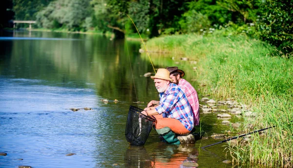 Fly Fishing Time. retired dad and mature bearded son. Catching and fishing. happy fishermen friendship. Two male friends fishing together. fly fish hobby of men in checkered shirt. retirement fishery — Stock Photo, Image