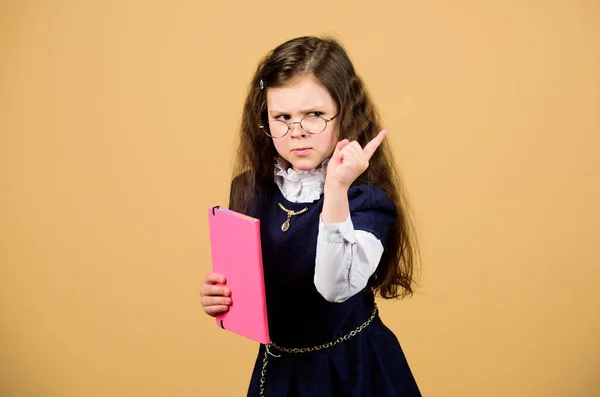 Connaissance et éducation. Je retourne à l'école. Travail à domicile. carnet pour notes de journal. leçon d'étude. petite fille avec dossier papier. petite fille sérieuse veut être professeur. Elle a le livre qu'il lui faut. — Photo