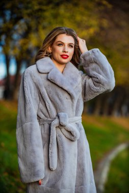 Kürk butiği. Sade ve sıcak. Çekici bir kadın. Hoş bir sonbahar kıyafeti. Kış moda trendleri. Lüks segment markası. Yumuşak ceketli kürklü doku. Seksi kırmızı dudaklı kadın kürk giyiyor. Kürklü iş kadını
