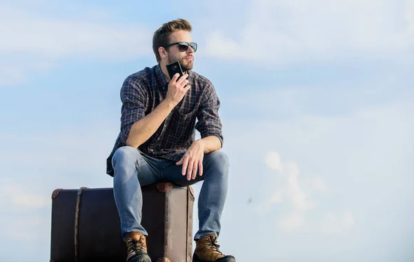 Installations de transport. Concept de bagage. Beau voyageur. Guy à l'extérieur avec valise vintage. J'appelle un taxi. Agence de voyage. Voyagez avec vos bagages. Blogueur de voyage. Homme assis sur une valise avant le voyage — Photo