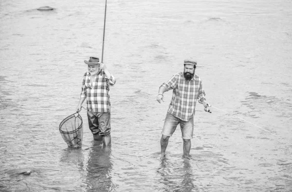 Lagkamrater. manlig vänskap. familje bindning. far och son fiske. sommar helgen. mogna män Fisher. två glada fiskare med fiskespö och nät. hobby-och idrottsaktiviteter. Öring bete — Stockfoto
