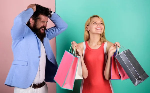 Presupuesto familiar. Comportamiento adictivo al consumismo. Un par en el centro comercial. Novia adicta a las compras. Concepto Viernes Negro. Mujer en gira de compras. Hombre chica con bolsas de papel. Adicta adicta a las compras. Problema de compras — Foto de Stock